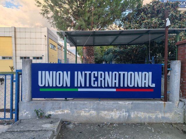 Union International fabrika girişi ve mavi pano tabela, geniş plan
