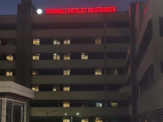 Torbalı Devlet Hastanesi çatısında kırmızı ışıklı harf tabela, gece görünümü